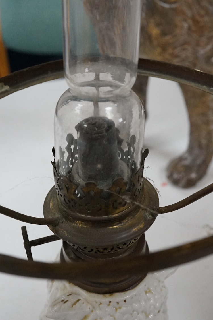 A pair of Paris porcelain oil lamps with white glazed porcelain stems modelled as owls (one lacking shade), 40cm high. Condition - fair
